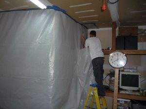 Water Damage Restoration Tech Sealing In Mold With A Vapor Barrier